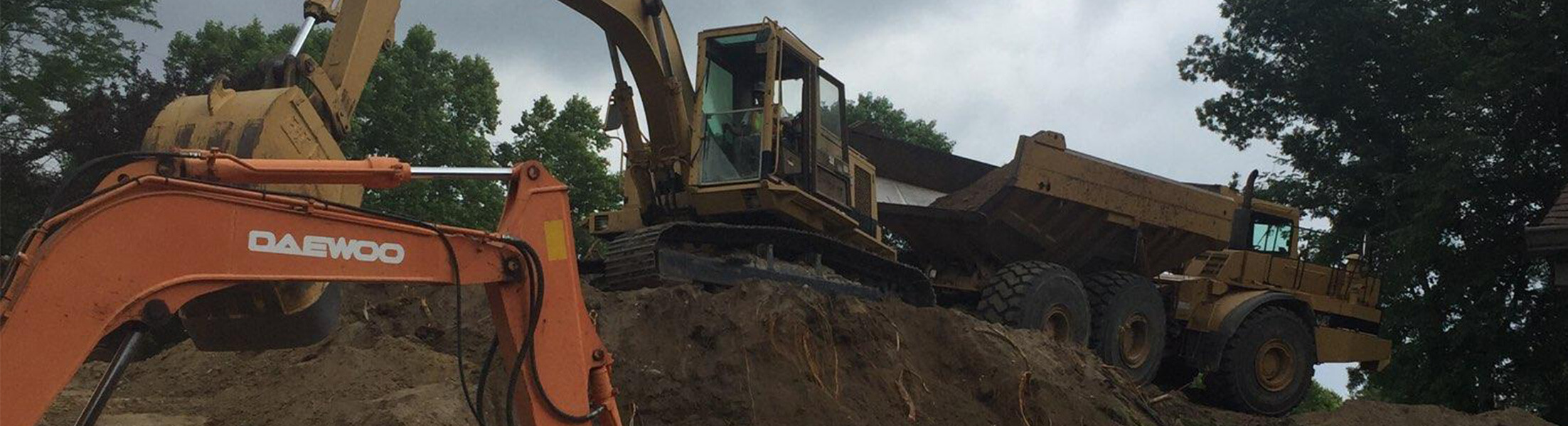 Two large excavators and a dump truck working at an excavating job site