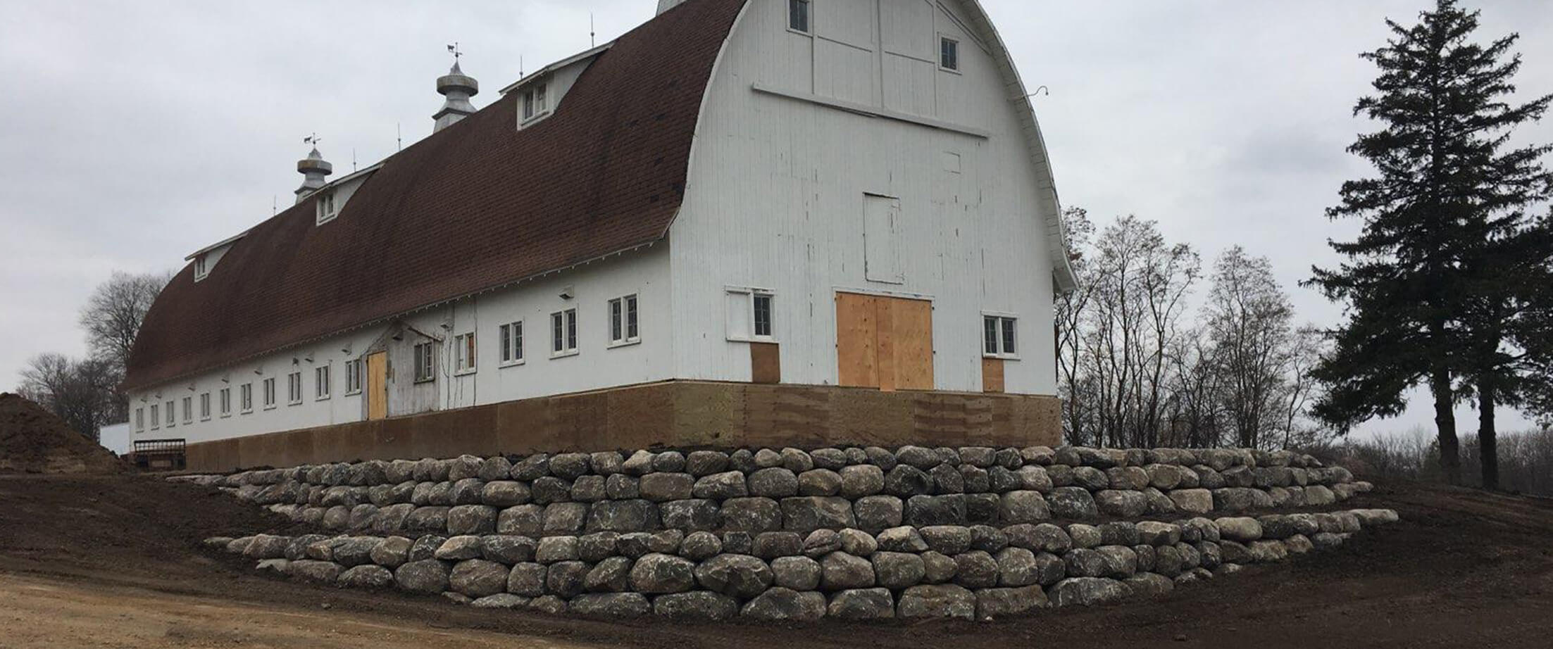 Fieldstone Boulder retaining wall around a barn