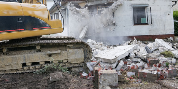 Pile of concrete rubble next to an excavator